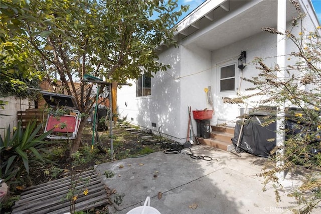 exterior space with crawl space, a patio, and stucco siding