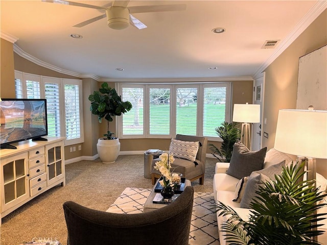 living area with plenty of natural light, visible vents, crown molding, and light colored carpet