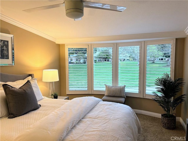 carpeted bedroom with crown molding, baseboards, and ceiling fan