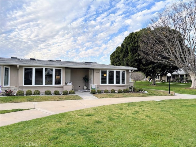 single story home featuring a front yard and stucco siding