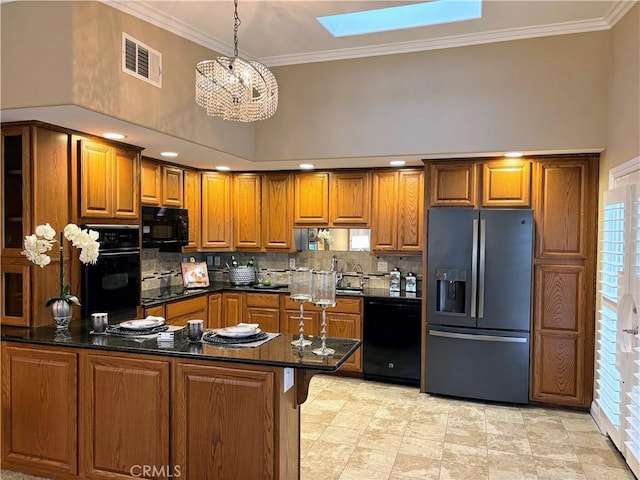 kitchen with visible vents, ornamental molding, brown cabinets, a peninsula, and black appliances