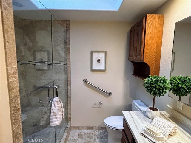 bathroom with baseboards, a shower stall, toilet, and vanity