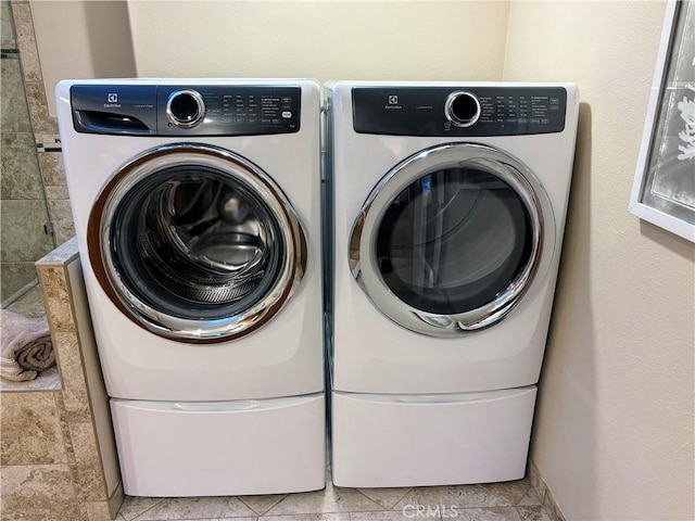 clothes washing area featuring laundry area and washer and clothes dryer