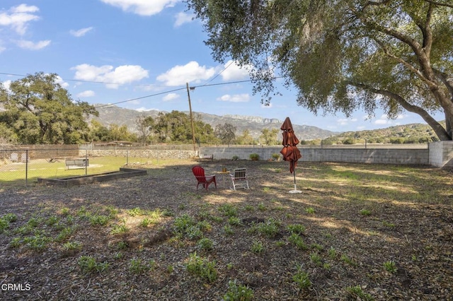 view of yard featuring fence and a mountain view