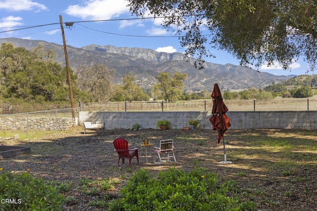 view of yard featuring fence and a mountain view