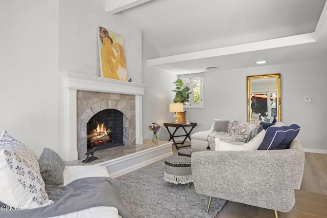 living room featuring vaulted ceiling with beams, wood finished floors, baseboards, and a premium fireplace