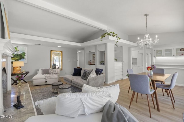 living area featuring baseboards, a chandelier, vaulted ceiling with beams, and light wood finished floors