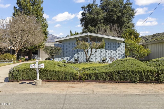 mid-century home with concrete block siding, a garage, and driveway