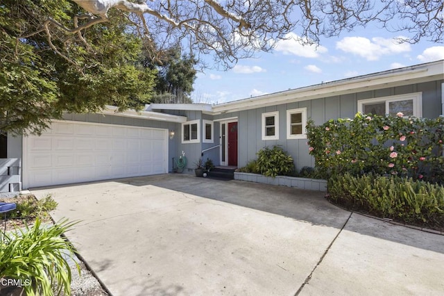 single story home featuring board and batten siding, concrete driveway, and an attached garage