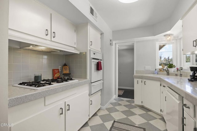 kitchen with light floors, white appliances, light countertops, and a sink