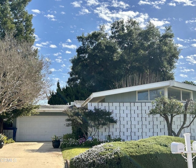 view of home's exterior featuring concrete driveway and a garage