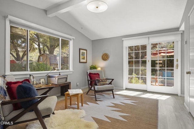 living area with lofted ceiling with beams, baseboards, and wood finished floors