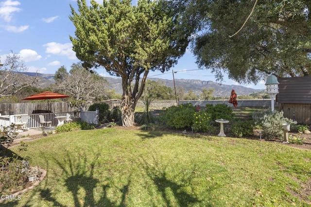 view of yard featuring fence and a mountain view