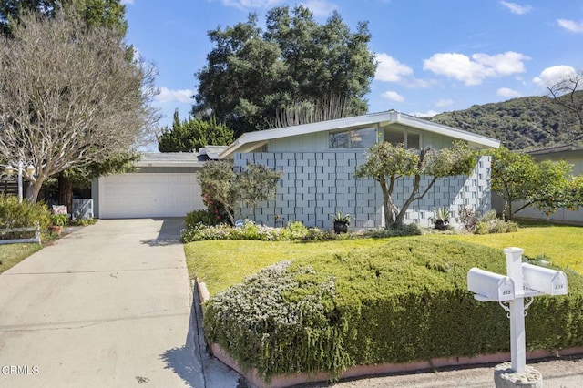 view of home's exterior with concrete driveway, a yard, and an attached garage