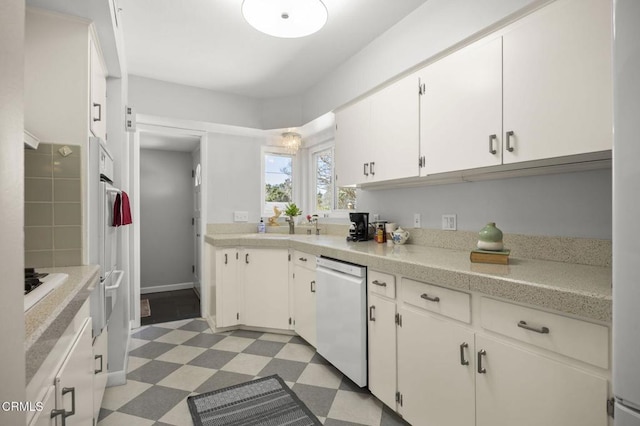 kitchen with light floors, white appliances, white cabinets, and light countertops