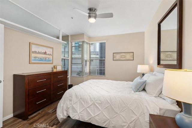 bedroom with ceiling fan, dark wood-type flooring, and baseboards