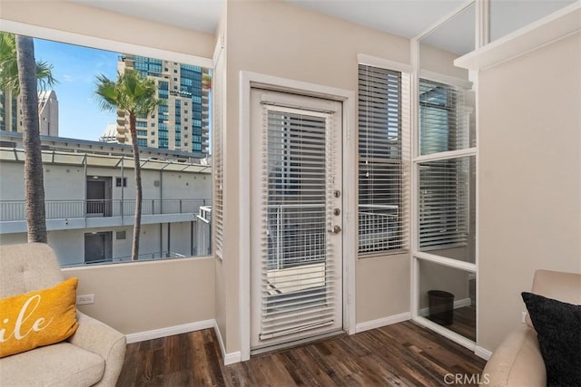 doorway to outside featuring wood finished floors and baseboards