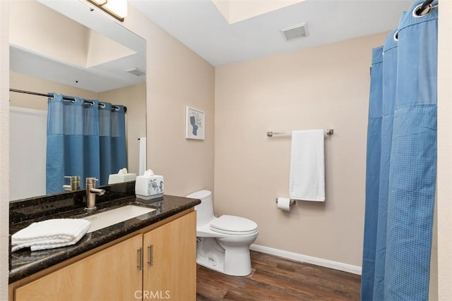 full bath with visible vents, toilet, vanity, wood finished floors, and baseboards