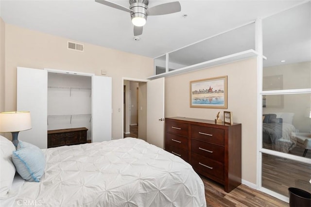 bedroom with ceiling fan, wood finished floors, and visible vents