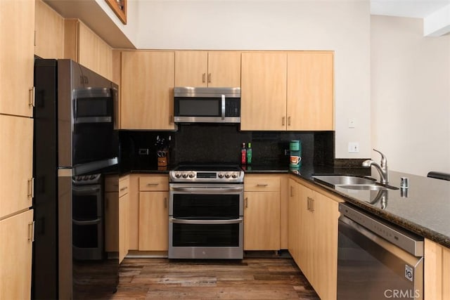 kitchen featuring dark wood-type flooring, a sink, appliances with stainless steel finishes, backsplash, and light brown cabinetry