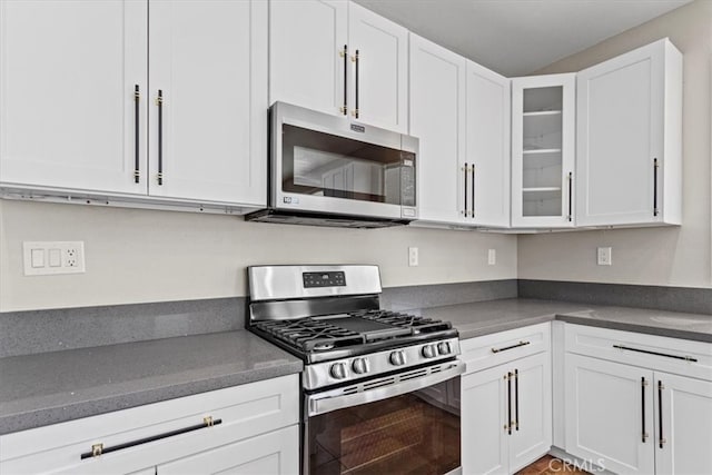 kitchen featuring glass insert cabinets, appliances with stainless steel finishes, and white cabinets