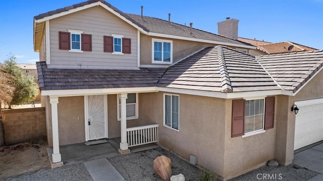 exterior space featuring a tile roof, a chimney, fence, a porch, and stucco siding