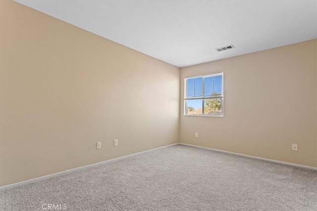 spare room with baseboards, visible vents, and carpet flooring