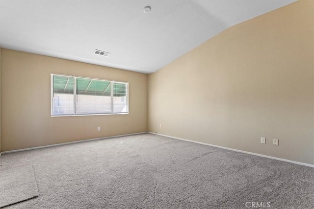 carpeted empty room featuring lofted ceiling, visible vents, and baseboards