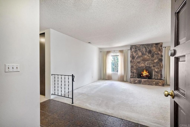 carpeted living area featuring a textured ceiling and a fireplace