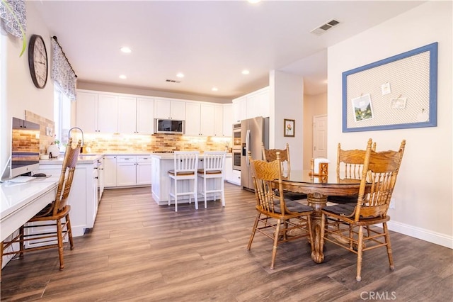 dining space with visible vents, recessed lighting, baseboards, and wood finished floors