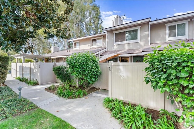 exterior space with fence private yard, a chimney, and stucco siding