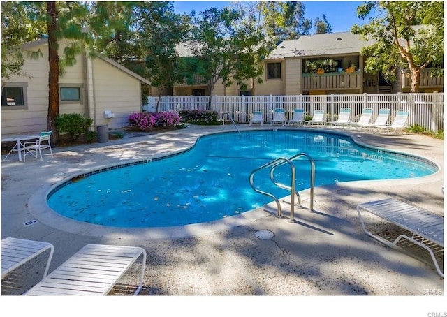 community pool featuring a patio and fence