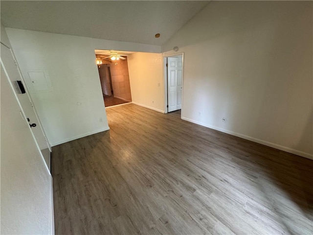 empty room with lofted ceiling, ceiling fan, baseboards, and wood finished floors