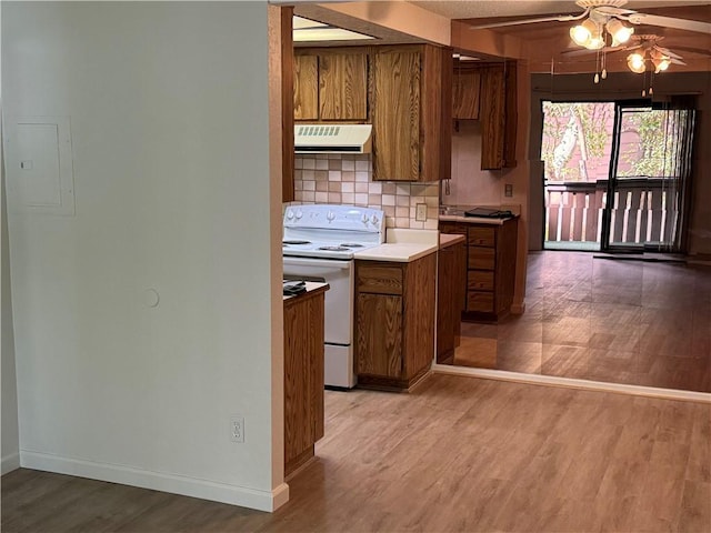 kitchen featuring brown cabinetry, exhaust hood, white electric range oven, and light wood-style floors