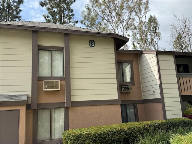 view of home's exterior with a shingled roof and stucco siding