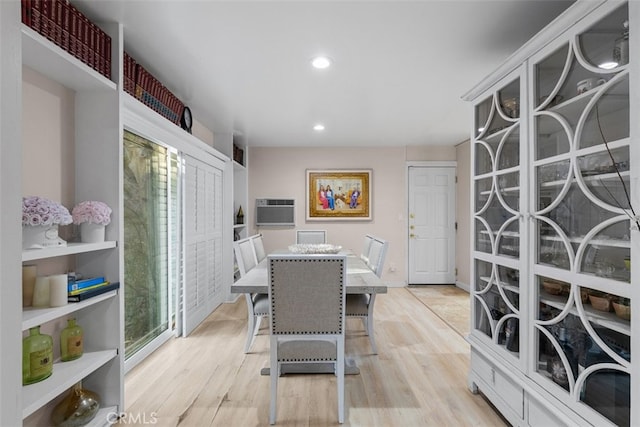 dining space with recessed lighting, a wall mounted air conditioner, and light wood-style floors