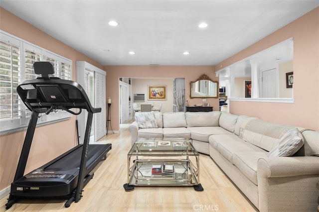 living room featuring recessed lighting, an AC wall unit, and wood finished floors