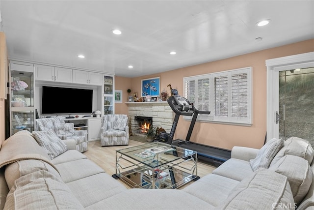 living room featuring a fireplace, light wood-style flooring, and recessed lighting