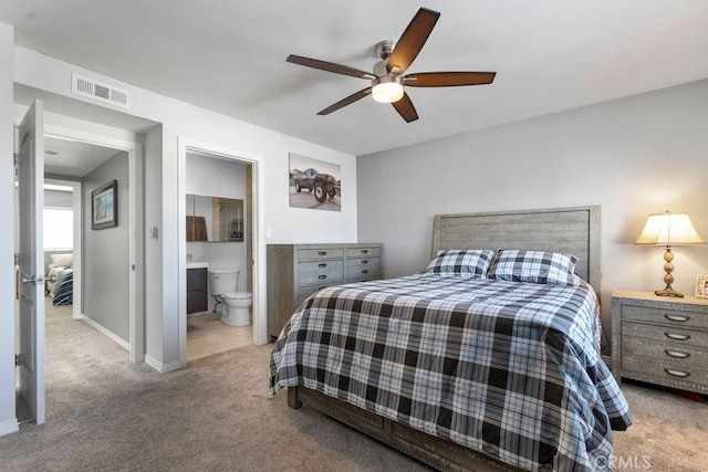 bedroom featuring ensuite bathroom, light carpet, a ceiling fan, visible vents, and baseboards