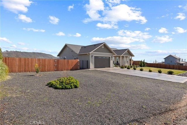 view of front of home featuring driveway, an attached garage, and fence