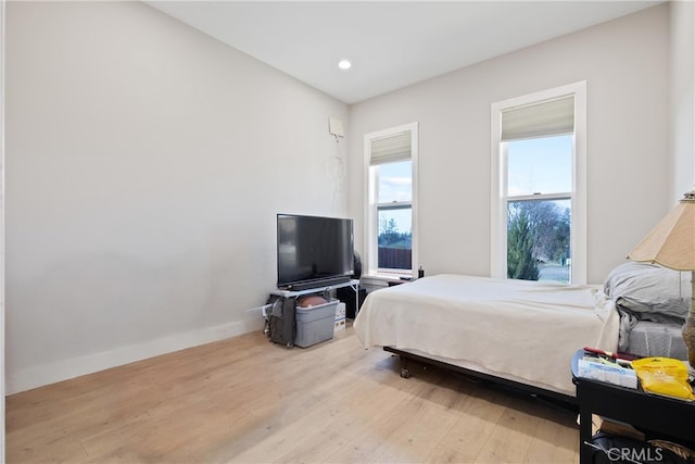 bedroom with recessed lighting, wood finished floors, and baseboards