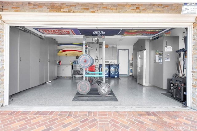 garage with freestanding refrigerator and washing machine and dryer