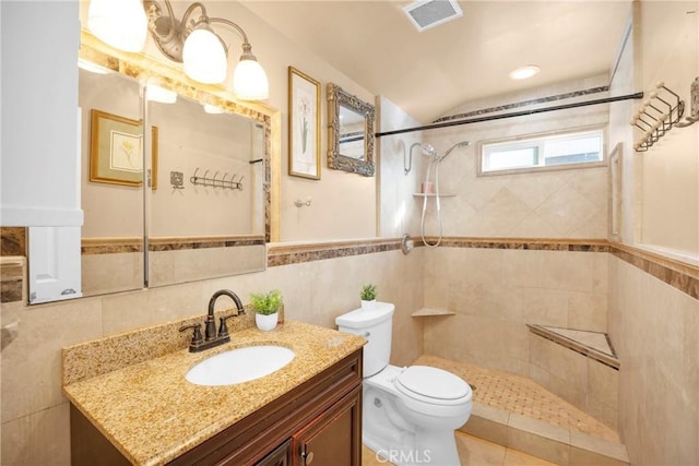 bathroom with visible vents, a tile shower, tile walls, and toilet