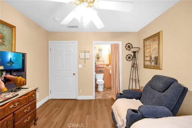 living area with ceiling fan, light wood-type flooring, visible vents, and baseboards