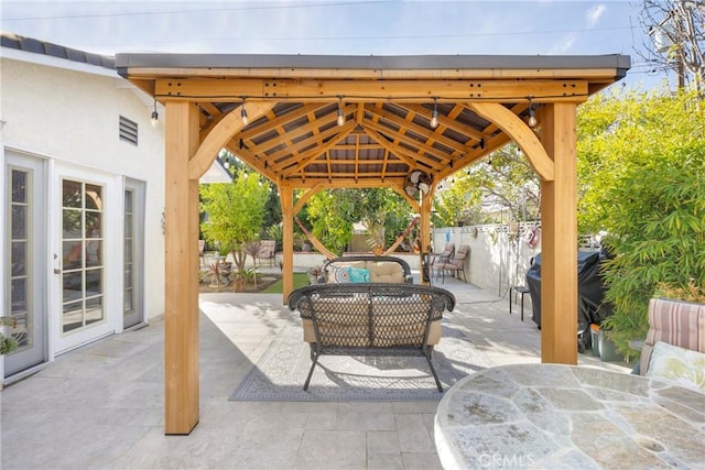 view of patio with outdoor dining area, fence, an outdoor hangout area, and a gazebo