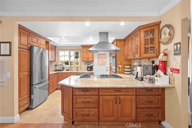 kitchen featuring stainless steel appliances, brown cabinets, a peninsula, and exhaust hood