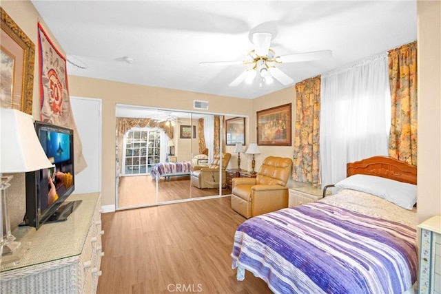 bedroom featuring a closet, visible vents, ceiling fan, and wood finished floors