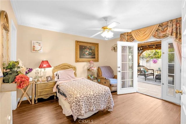 bedroom with access to exterior, crown molding, wood finished floors, and french doors