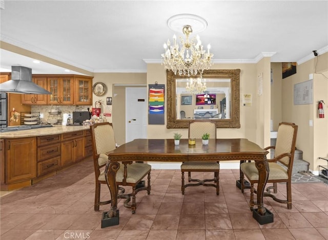 dining area featuring an inviting chandelier, ornamental molding, and light tile patterned flooring