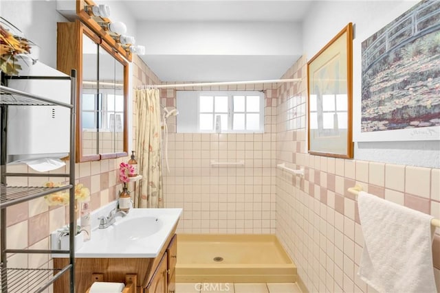 bathroom featuring vanity, tile walls, and tiled shower